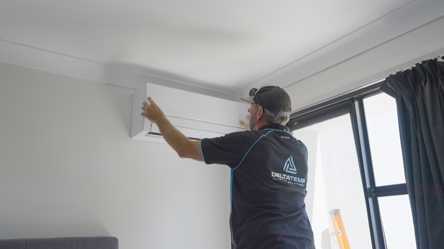 Delta Temp technician fitting a wall mounted split system indoor unit