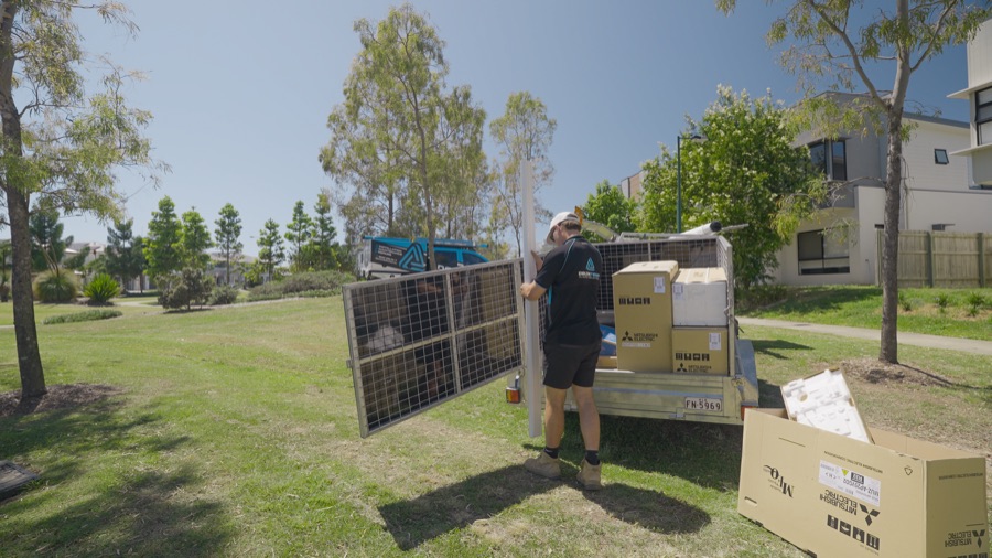 Delta Temp technician unloading boxed air conditioning equipment from a trailer