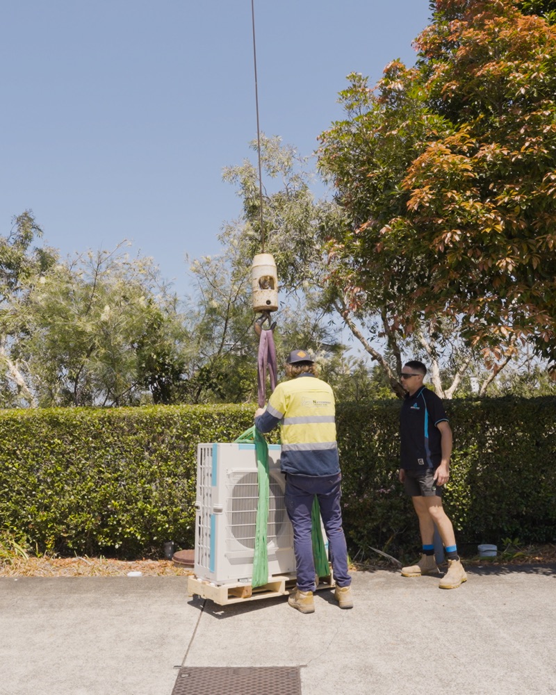 Lifting an outdoor unit into place on a complex