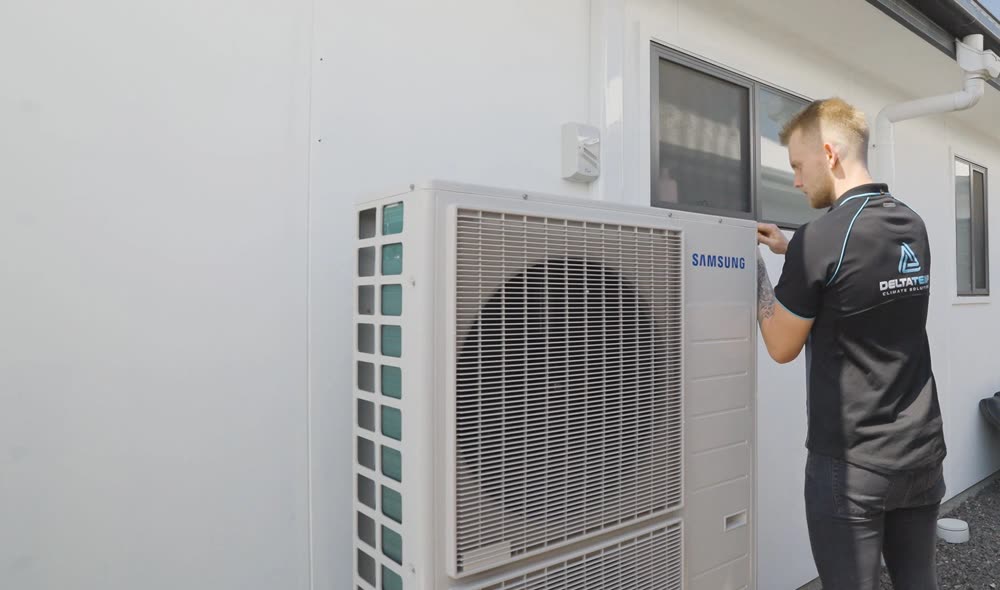 A technician checking an outdoor unit